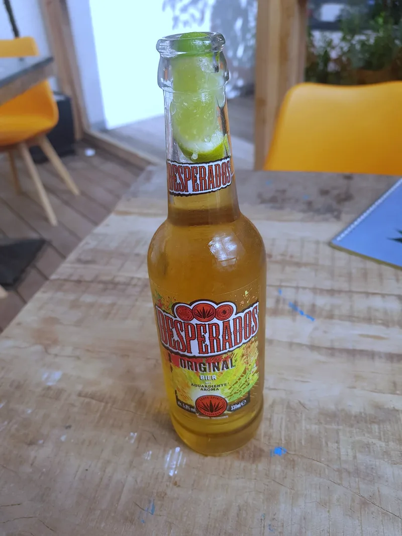 Eine Flasche Desperados auf einem Tisch im Freien.